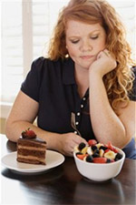 Woman at table with cake and fruit salad